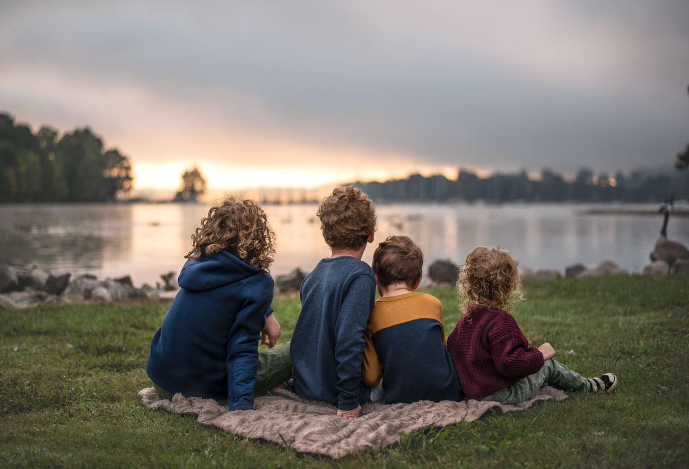 kids sitting by lake at sunrise