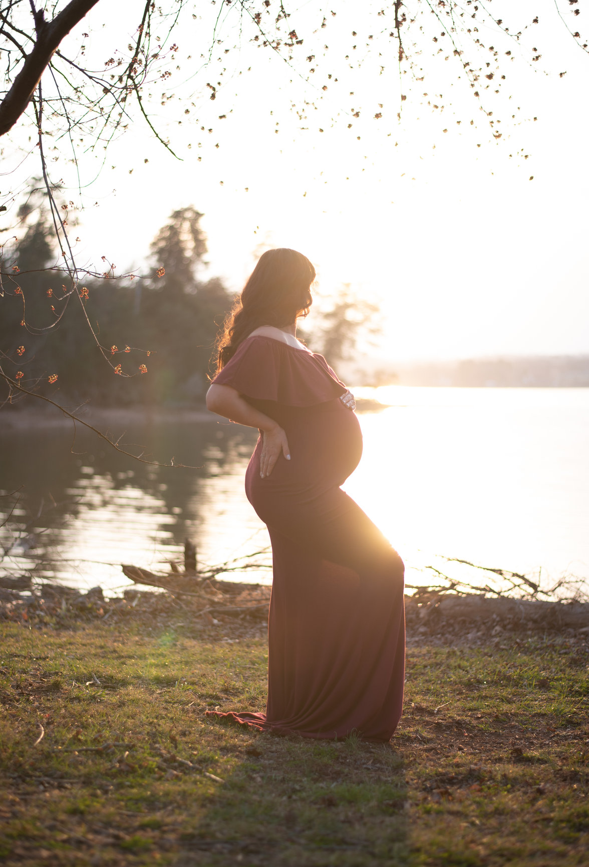 backlit portrait ideas pregnant woman by water red dress