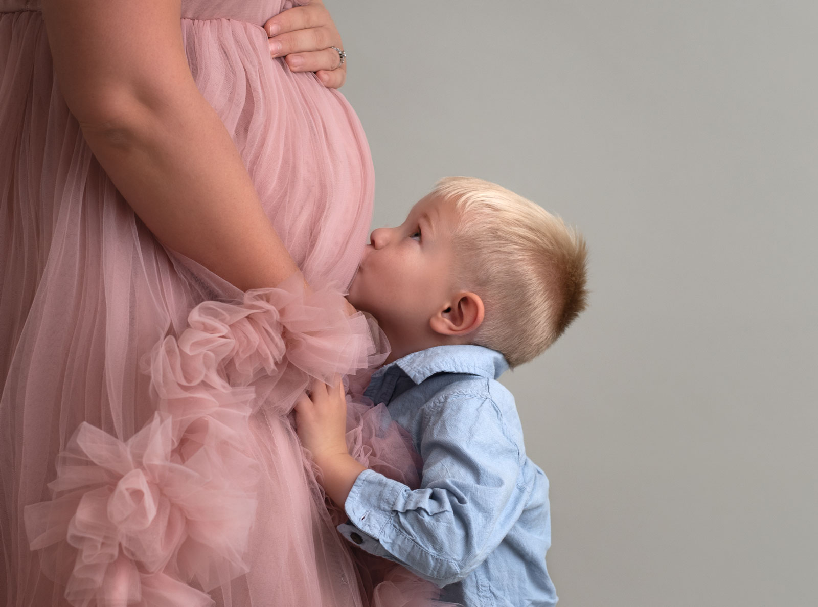 little boy kissing his mom's baby bump St Louis Midwife