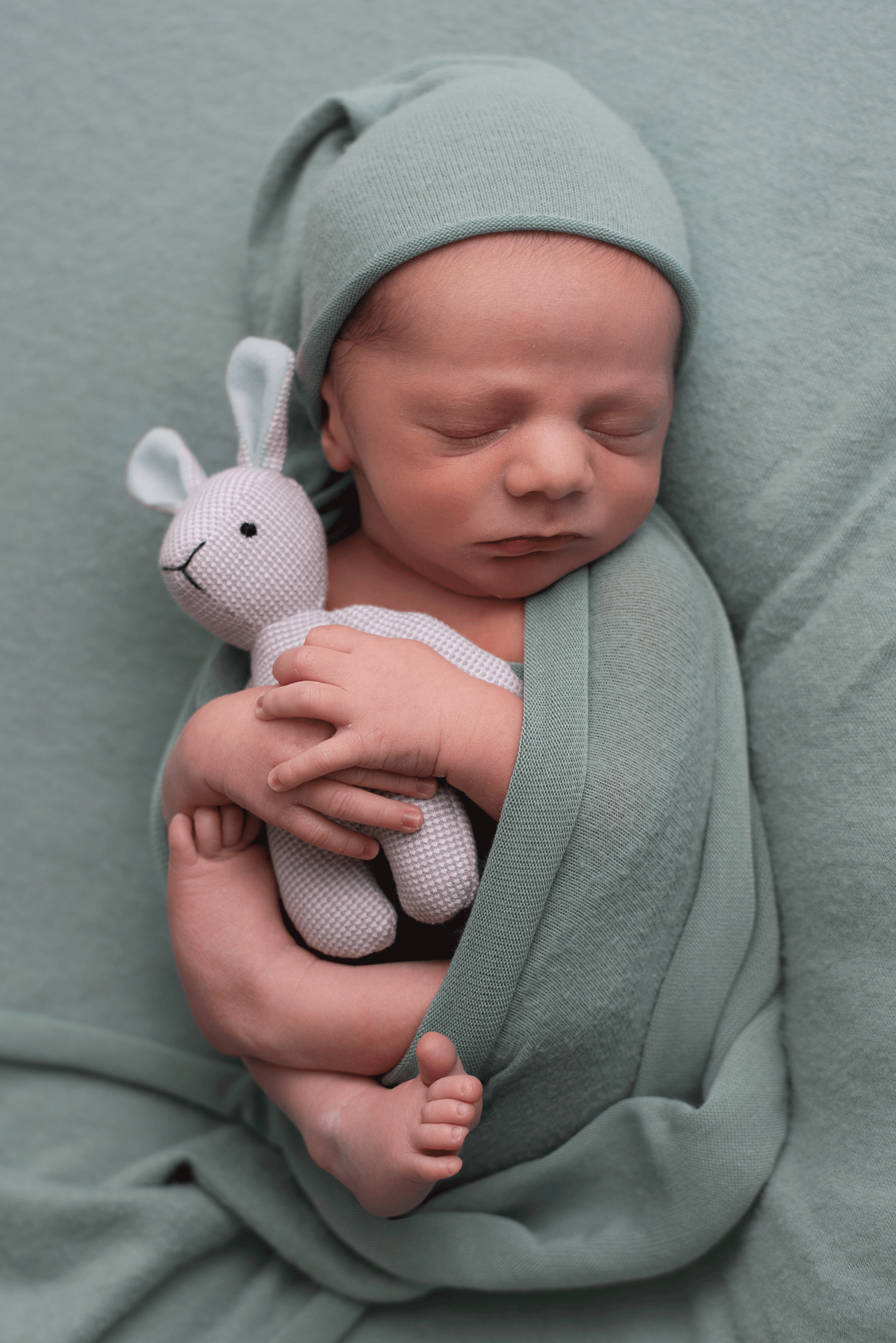 newborn baby wrapped in seafoam colored blanket