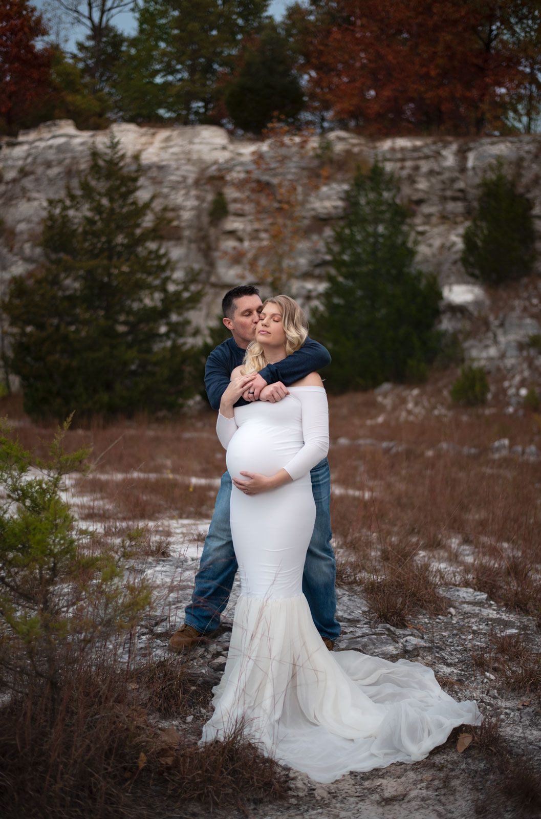 pregnant woman and her husband hugging in the snow